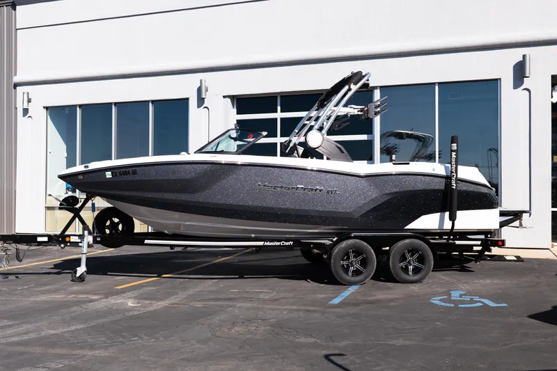 Slide: The Image of 2023 MasterCraft NXT22 boat on trailer, parked outside a building. - 4