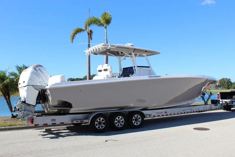 Slide: The Image of 2018 Fountain 38 CC Tournament Edition boat on trailer, palm trees in background. - 19