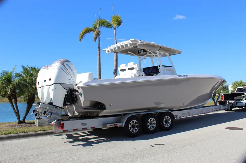 Slide: The Image of 2018 Fountain 38 CC Tournament Edition boat on trailer by palm trees. - 20