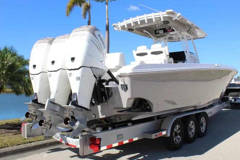 Slide: The Image of 2018 Fountain 38 CC Tournament Edition boat on trailer, triple engines, sunny day. - 22