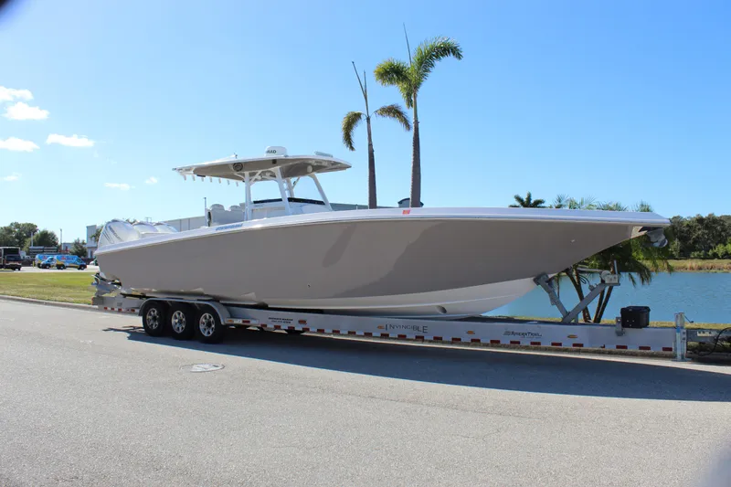Slide: The Image of 2018 Fountain 38 CC Tournament Edition boat on trailer by a lake. - 36