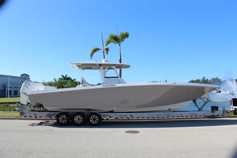 Slide: The Image of 2018 Fountain 38 CC Tournament Edition boat on trailer, sunny day, palm trees in background. - 37