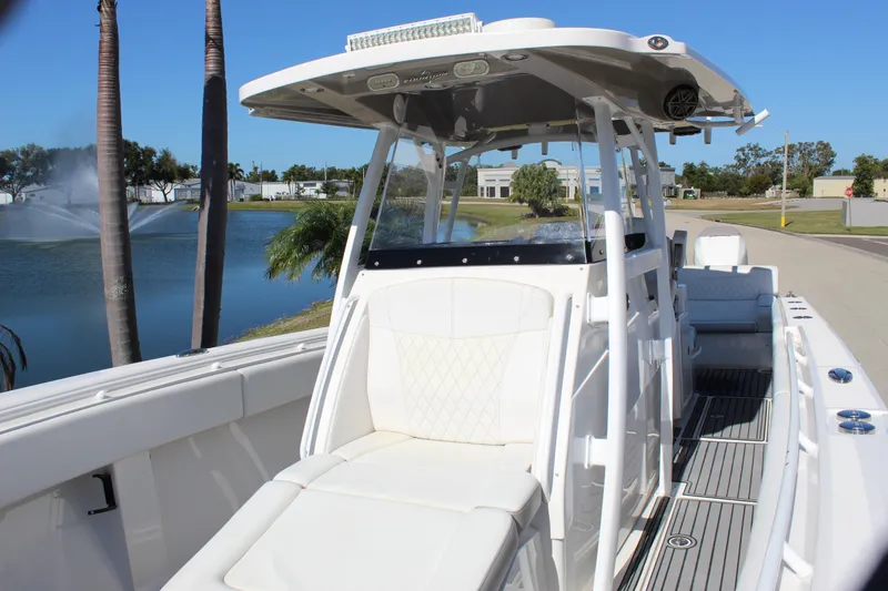 Slide: The Image of 2019 Fountain 38 CC Tournament Edition boat by a lake with palm trees. - 42