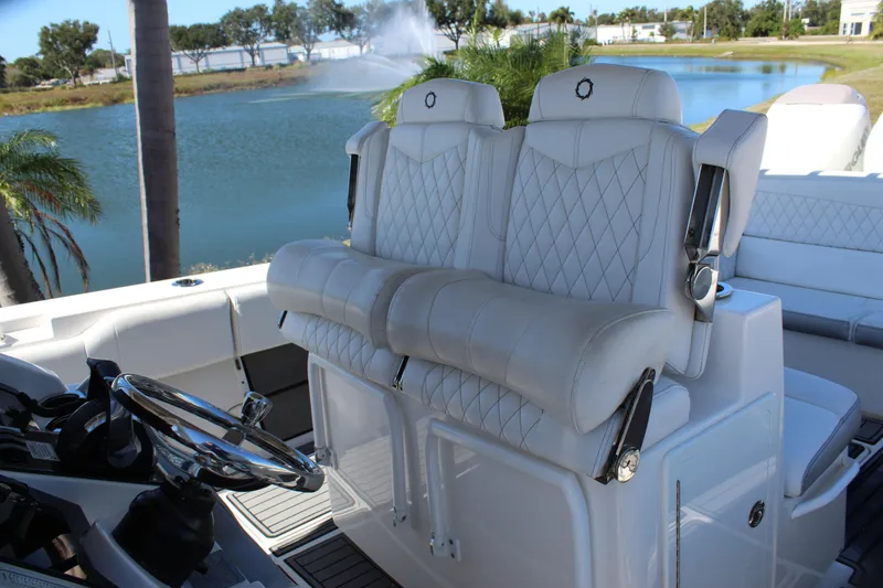 Slide: The Image of 2019 Fountain 38 CC Tournament Edition boat with luxurious white seating by a lake. - 46