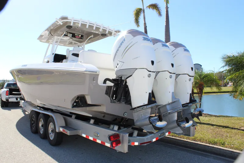 Slide: The Image of 2018 Fountain 38 CC Tournament Edition boat on trailer with triple outboard engines. - 7