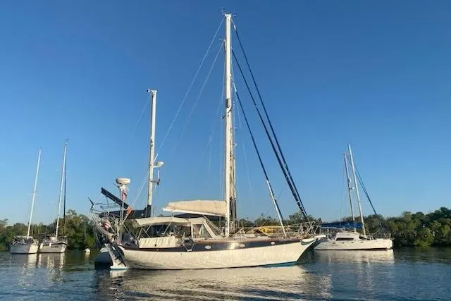 Slide: The Image of 1977 Ericson 36 C sailboat anchored on calm water under clear blue sky. - 1
