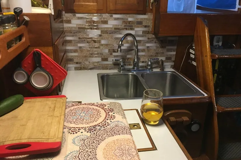 Slide: The Image of Cozy kitchen area in a 1977 Ericson 36 C sailboat with sink and cutting board. - 11