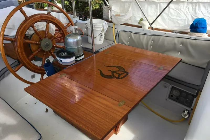 Slide: The Image of 1977 Ericson 36 C sailboat cockpit with wooden wheel and table, nautical decor. - 15