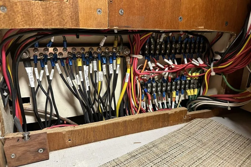 Slide: The Image of Electrical wiring panel inside a 1977 Ericson 36 C boat, showcasing organized cables and connectors. - 22