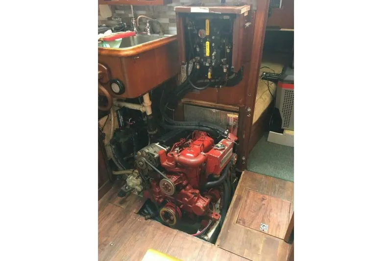 Slide: The Image of Engine compartment of a 1977 Ericson 36 C sailboat, featuring a red engine and wooden interior. - 23