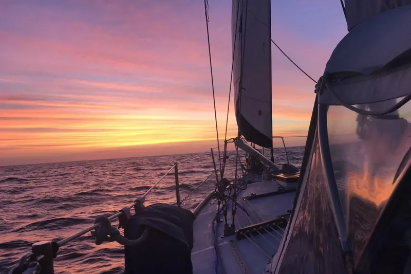 Slide: The Image of Sailing on a 1977 Ericson 36 C at sunset with vibrant sky reflections. - 3