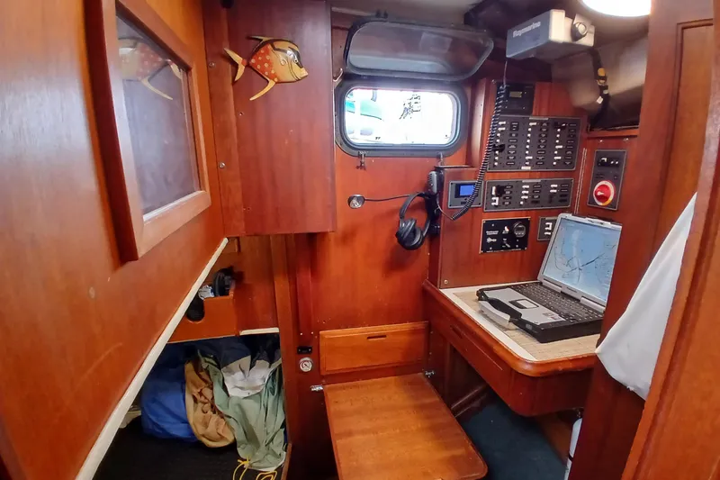 Slide: The Image of Navigation station inside a 1977 Ericson 36 C sailboat with control panels and laptop. - 34