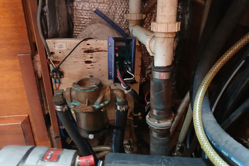 Slide: The Image of Engine compartment of a 1977 Ericson 36 C sailboat with visible plumbing and wiring. - 46