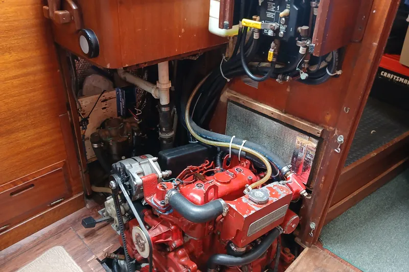 Slide: The Image of Engine compartment of a 1977 Ericson 36 C sailboat, featuring a red marine engine. - 48