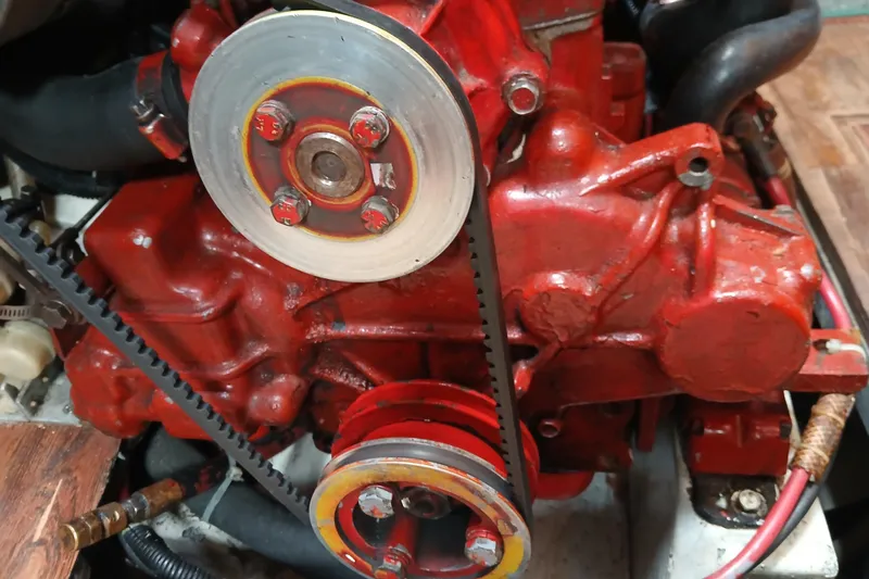Slide: The Image of Red engine of a 1977 Ericson 36 C sailboat, featuring visible belts and pulleys. - 49