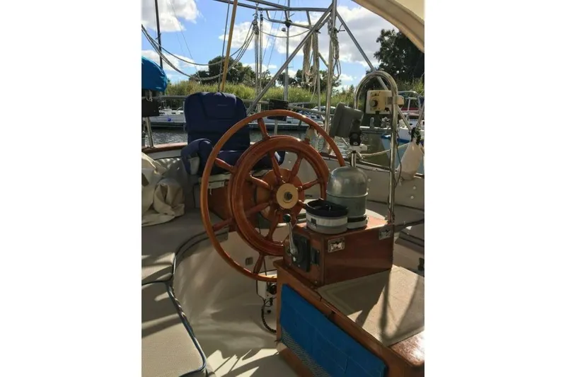 Slide: The Image of 1977 Ericson 36 C sailboat cockpit with wooden steering wheel and navigation equipment. - 5