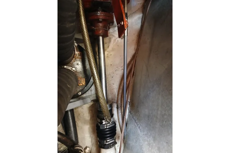 Slide: The Image of Engine compartment of a 1977 Ericson 36 C sailboat, showing mechanical components and hoses. - 50