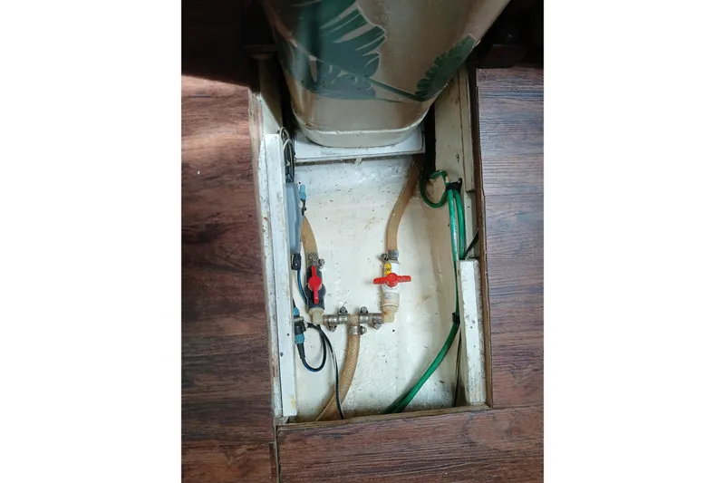 Slide: The Image of Boat plumbing system in a 1977 Ericson 36 C, featuring hoses and valves. - 51