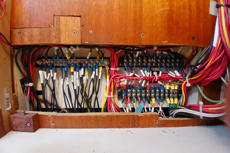 Slide: The Image of Electrical wiring panel inside a 1977 Ericson 36 C sailboat, showcasing organized cables and connectors. - 55