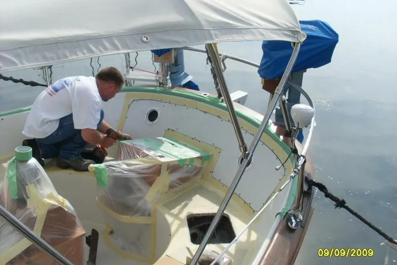 Slide: The Image of Man working on 1977 Ericson 36 C sailboat deck, preparing for maintenance. - 56