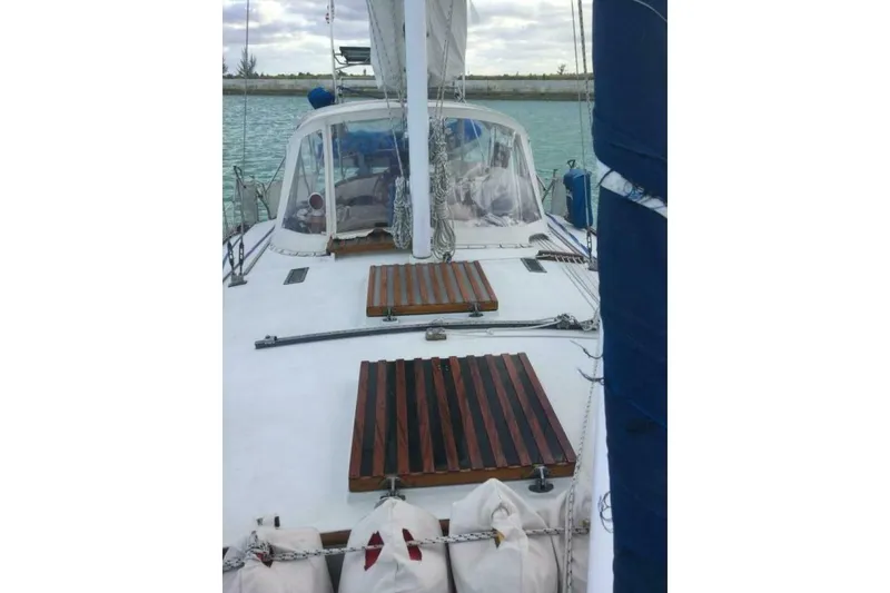 Slide: The Image of 1977 Ericson 36 C sailboat deck with wooden hatches and blue sail cover. - 61