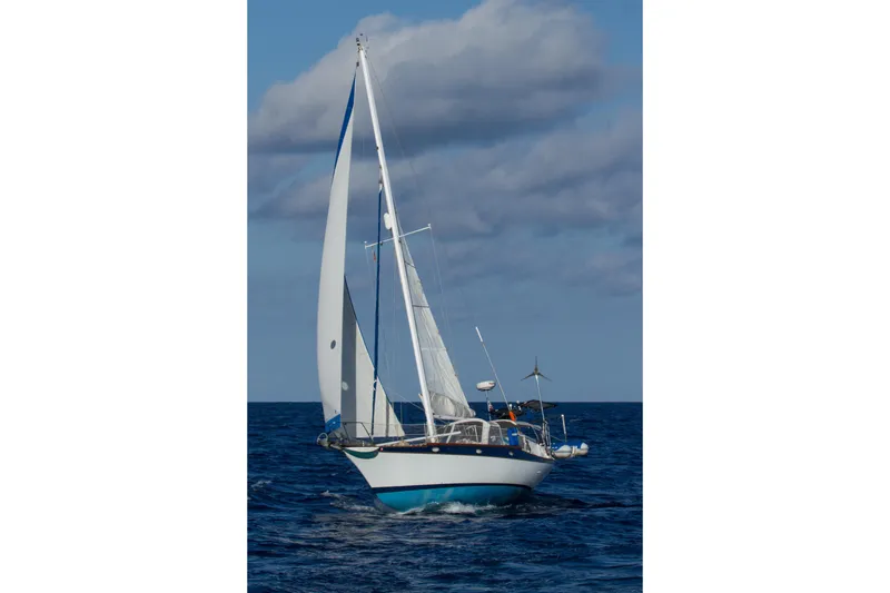 Slide: The Image of 1977 Ericson 36 C sailboat navigating open sea under cloudy sky. - 67