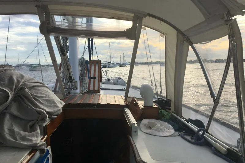 Slide: The Image of Interior view of 1977 Ericson 36 C sailboat cockpit with marina in background. - 7