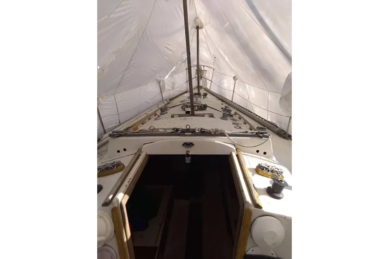 Slide: The Image of 1975 WDS Santana sailboat deck under cover, showing mast and rigging. - 10