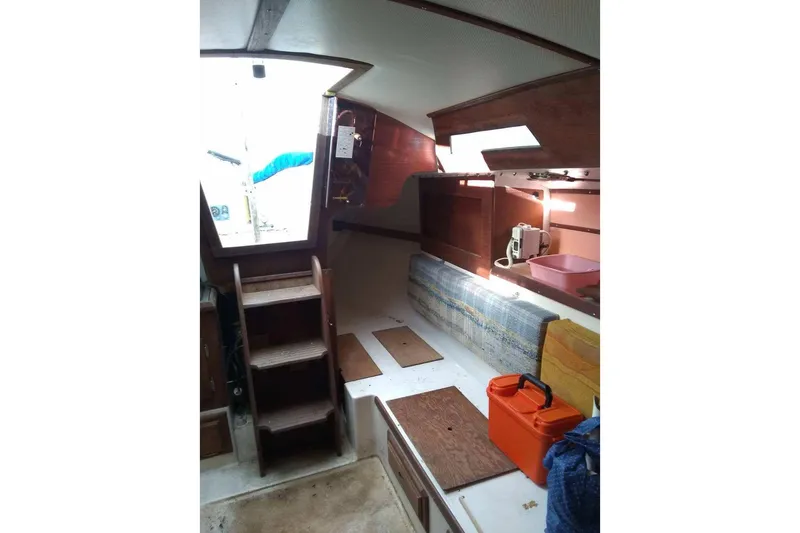 Slide: The Image of 1975 WDS Santana boat interior with wooden steps, seating, and storage. - 13