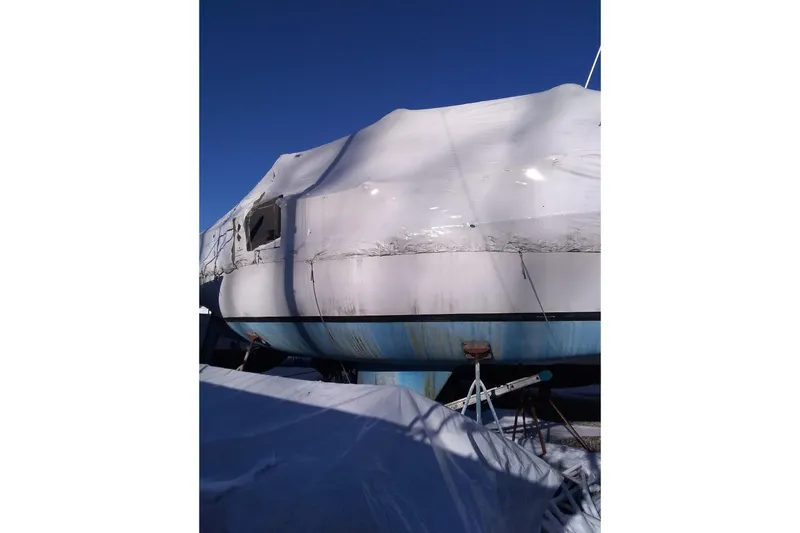 Slide: The Image of 1975 Schock Santana boat covered with tarp outdoors. - 3