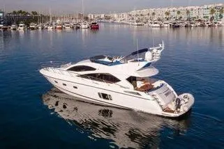 Slide: The Image of 2010 Sunseeker Manhattan 60 yacht cruising in a marina with calm waters. - 2