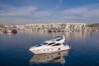 Slide: The Image of 2010 Sunseeker Manhattan 60 yacht cruising in a marina with waterfront buildings. - 36