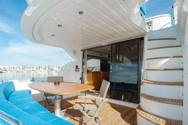 Slide: The Image of Sunseeker Manhattan 60 yacht deck with seating, table, and stairs, 2010 model. - 5