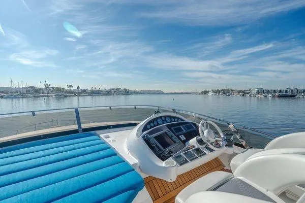 Slide: The Image of Flybridge view of 2010 Sunseeker Manhattan 60 yacht with serene waterfront backdrop. - 8