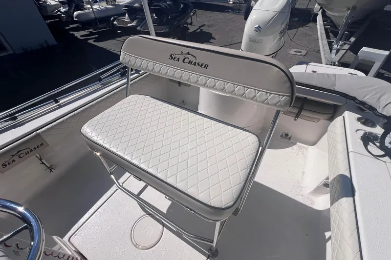 Slide: The Image of 2020 Sea Chaser 21 Sea Skiff boat interior with cushioned seating and steering wheel. - 16