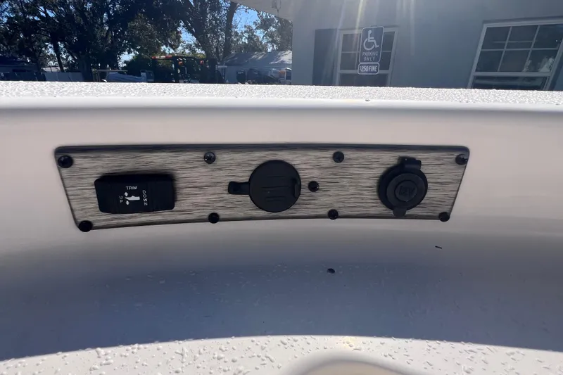 Slide: The Image of Control panel on 2020 Sea Chaser 21 Sea Skiff boat, featuring trim and power outlets. - 32