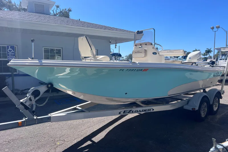 Slide: The Image of 2020 Sea Chaser 21 Sea Skiff boat on trailer, light blue hull, parked outdoors. - 4