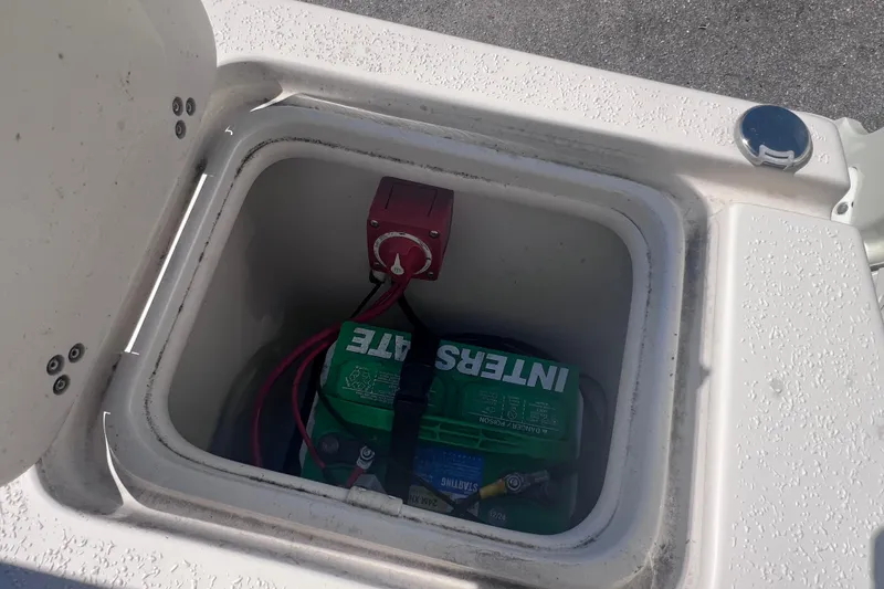 Slide: The Image of Battery compartment of 2020 Sea Chaser 21 Sea Skiff with visible wiring and switch. - 9