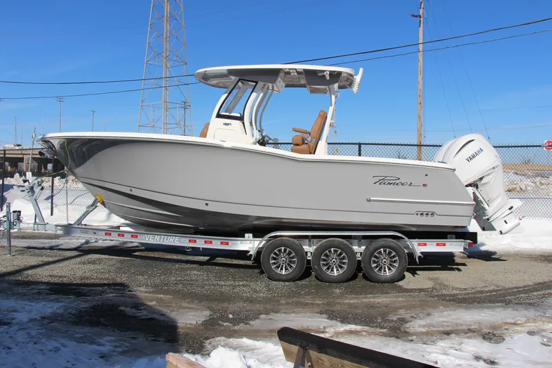 Slide: The Image of 2026 Pioneer 270 Pelagic boat on trailer, parked outdoors in snowy setting. - 2