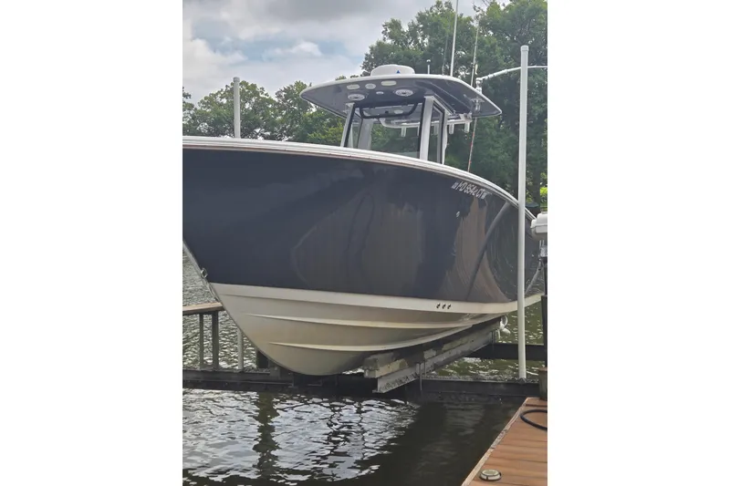Slide: The Image of 2022 Sportsman Open 262 Center Console boat docked on a lift. - 3