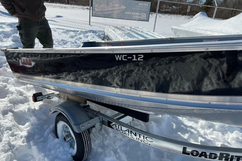 Slide: The Image of 2026 Lund WC-12 boat interior with snow, showcasing riveted aluminum construction. - 5