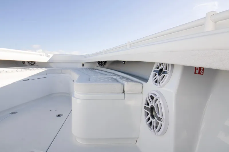 Slide: The Image of 2025 Yellowfin 32 Offshore boat interior with cushioned seating and built-in speakers. - 10