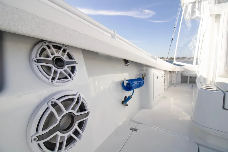 Slide: The Image of 2025 Yellowfin 32 Offshore boat interior with speakers and coiled hose. - 11