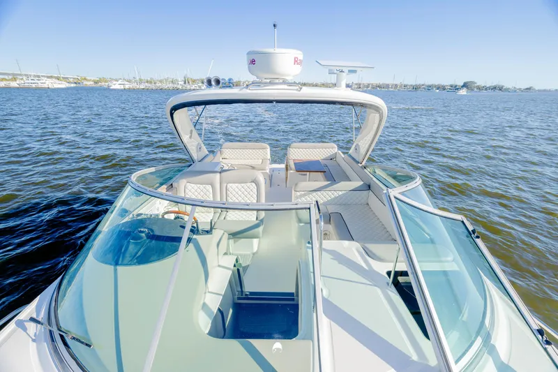 Slide: The Image of 2013 Sea Ray 370 Venture boat on water, featuring spacious seating and sleek design. - 10