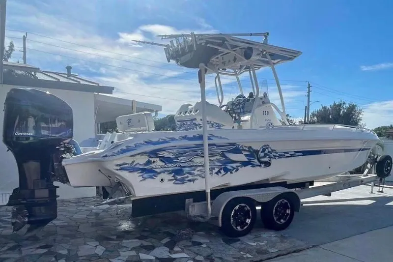 The Image of 2010 Glasstream 280 SCX boat on trailer, featuring vibrant blue graphics and powerful outboard motor. - 0