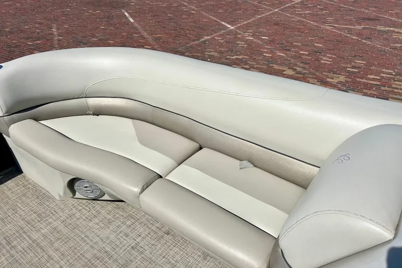 Slide: The Image of 2023 Cypress Cay Seabreeze 232 boat interior with beige seating and speaker. - 12