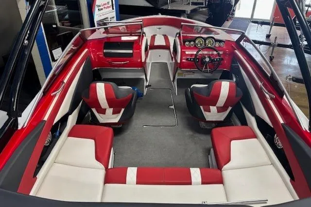 Slide: The Image of 2014 Glastron GTS 225 boat interior with red and white seating, modern dashboard. - 2