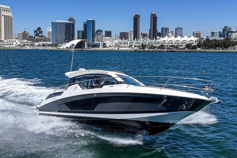 Slide: The Image of 2020 Four Winns Vista 355 Coupe OB cruising near city skyline on sunny day. - 1