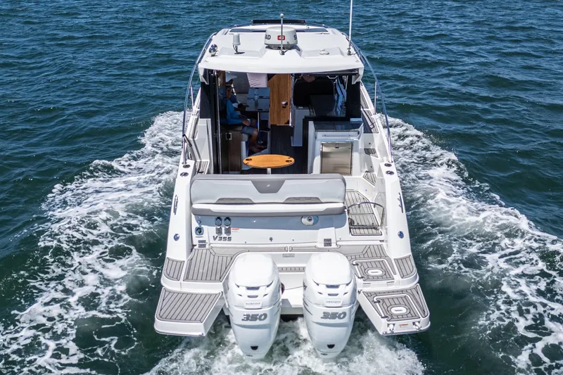 Slide: The Image of 2020 Four Winns Vista 355 Coupe OB cruising on open water, rear view. - 12