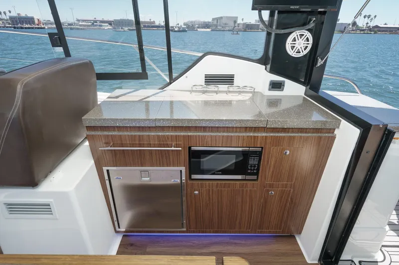 Slide: The Image of 2020 Four Winns Vista 355 Coupe OB yacht interior with kitchenette, featuring microwave and storage. - 28